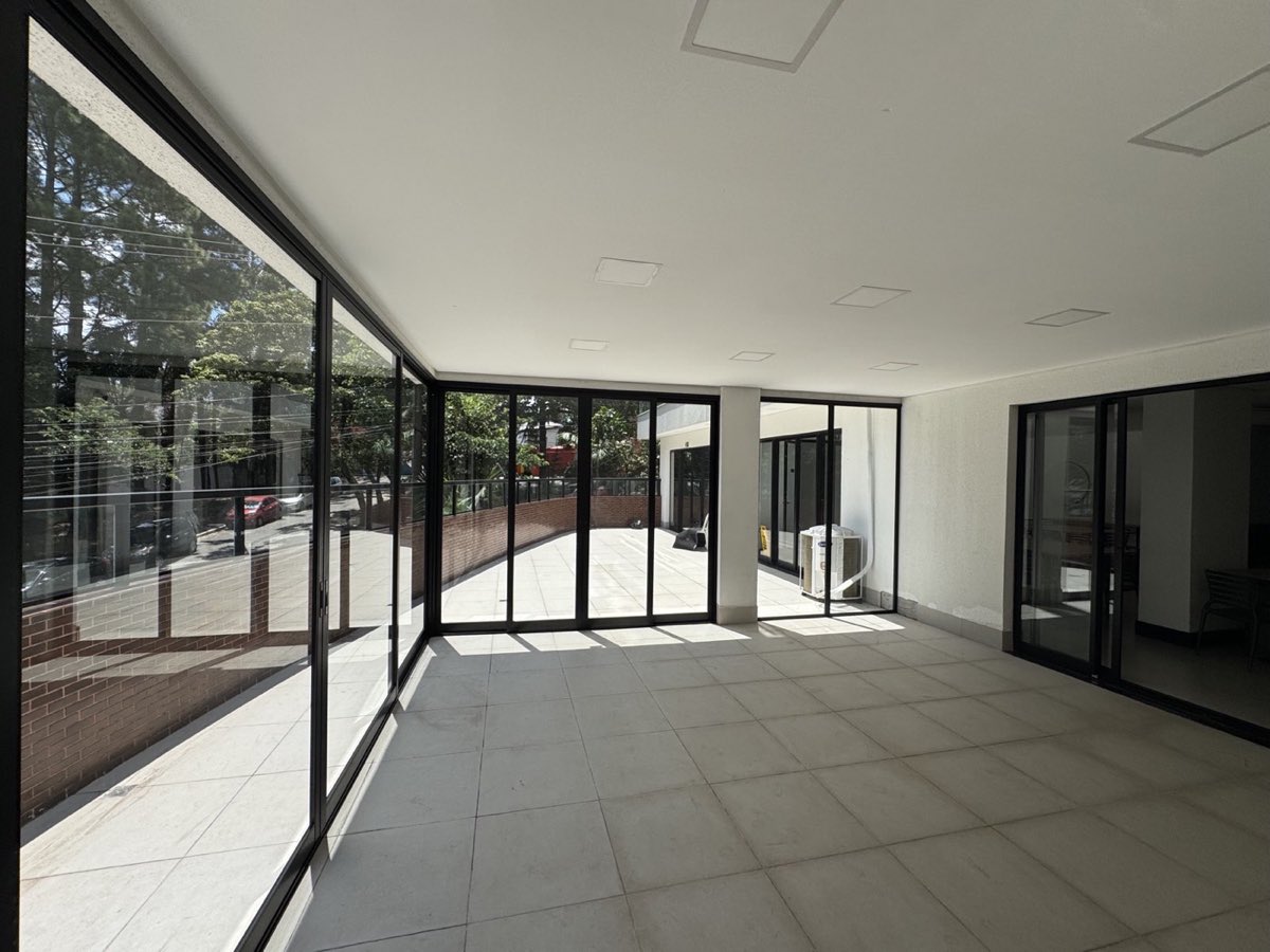 Porta de correr de 4 folhas em alumínio preto da linha Suprema em ambiente integrado.