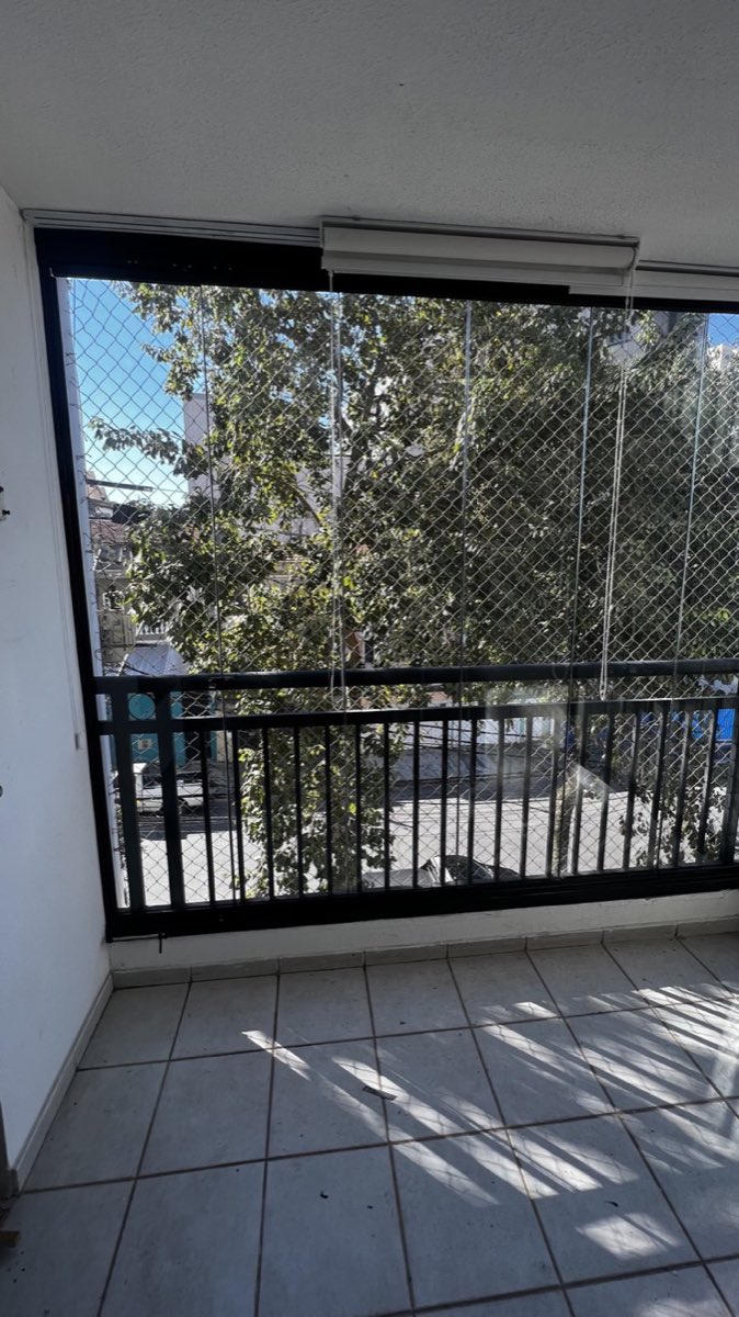 Varanda de apartamento com envidraçamento de vidro e guarda-corpo metálico.