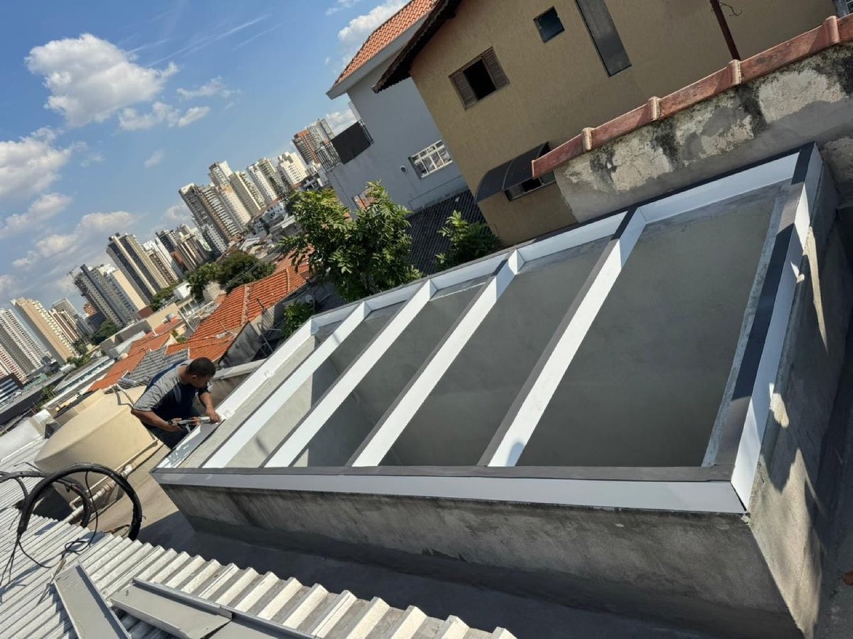 Cobertura de vidro com estrutura de alumínio instalada em área externa.