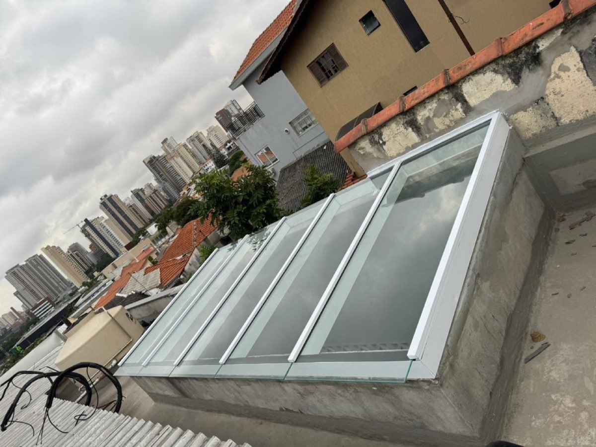 Vista lateral de cobertura de vidro com perfis de alumínio branco.
