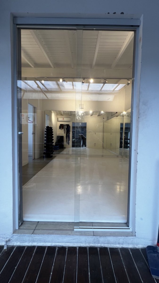 Pano de vidro sob medida instalado em corredor de área comum.