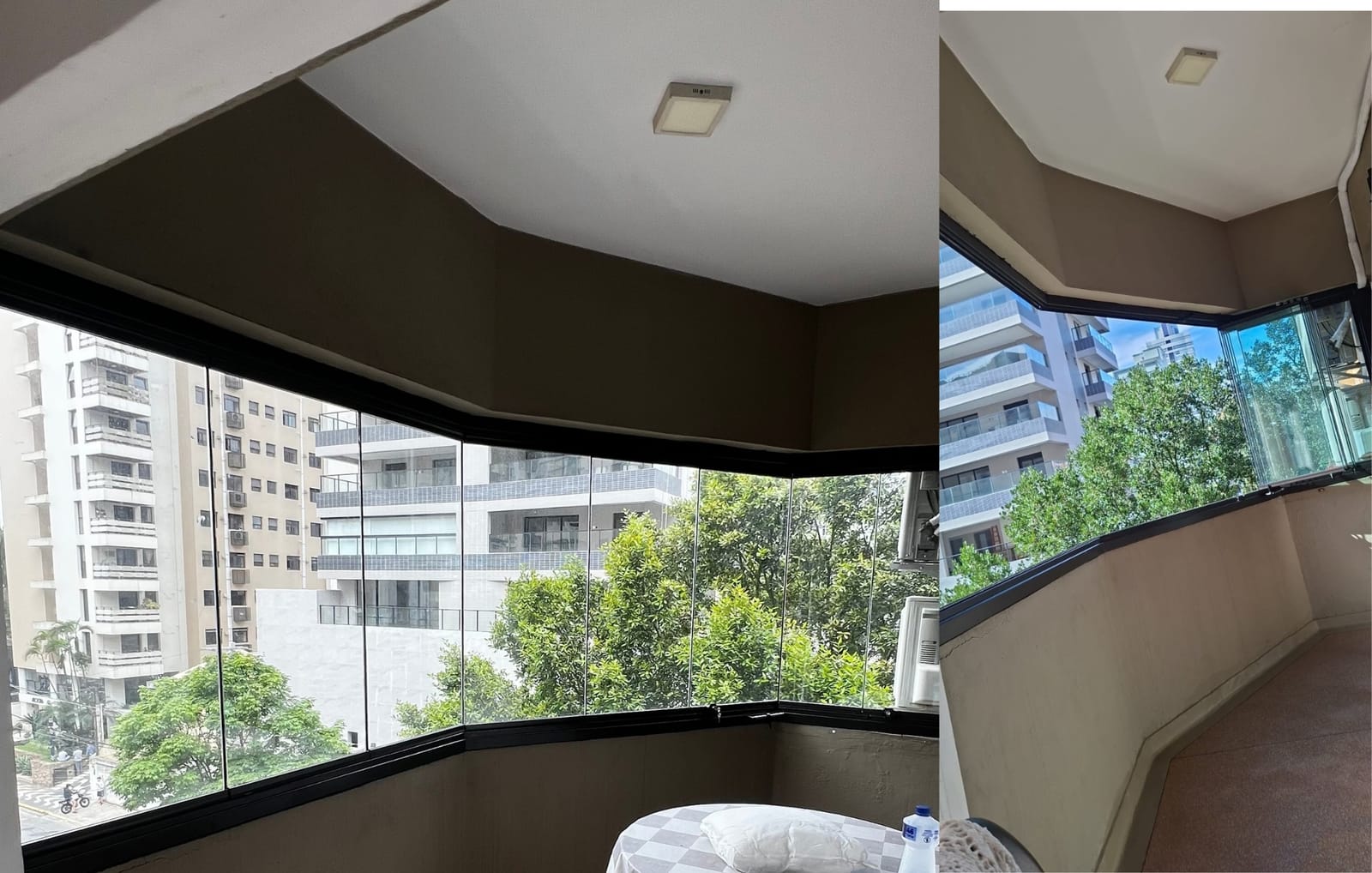Sacada curva de apartamento fechada com vidro e esquadria preta, com vista arborizada. Obra da VitraAlu em Santos.